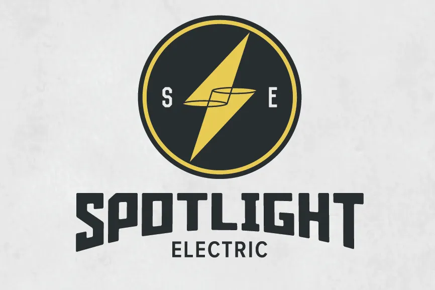 round logo with a yellow lighting bolt made of two cones and the text “spotlight electric”
